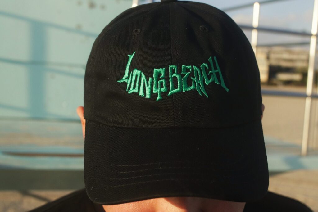 Black cap with neon green 'Long Beach' embroidery.