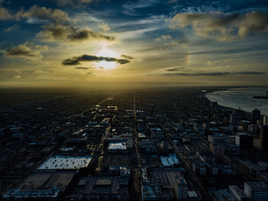 Sunset over a sprawling cityscape with dramatic clouds.