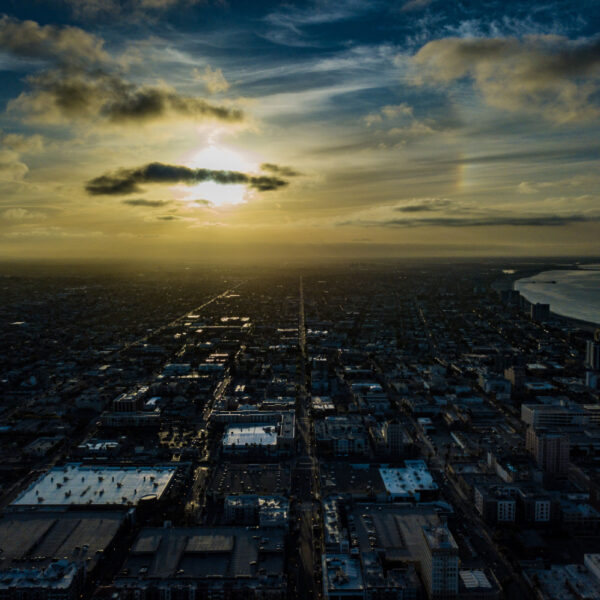 Sunset over a sprawling cityscape with dramatic clouds.